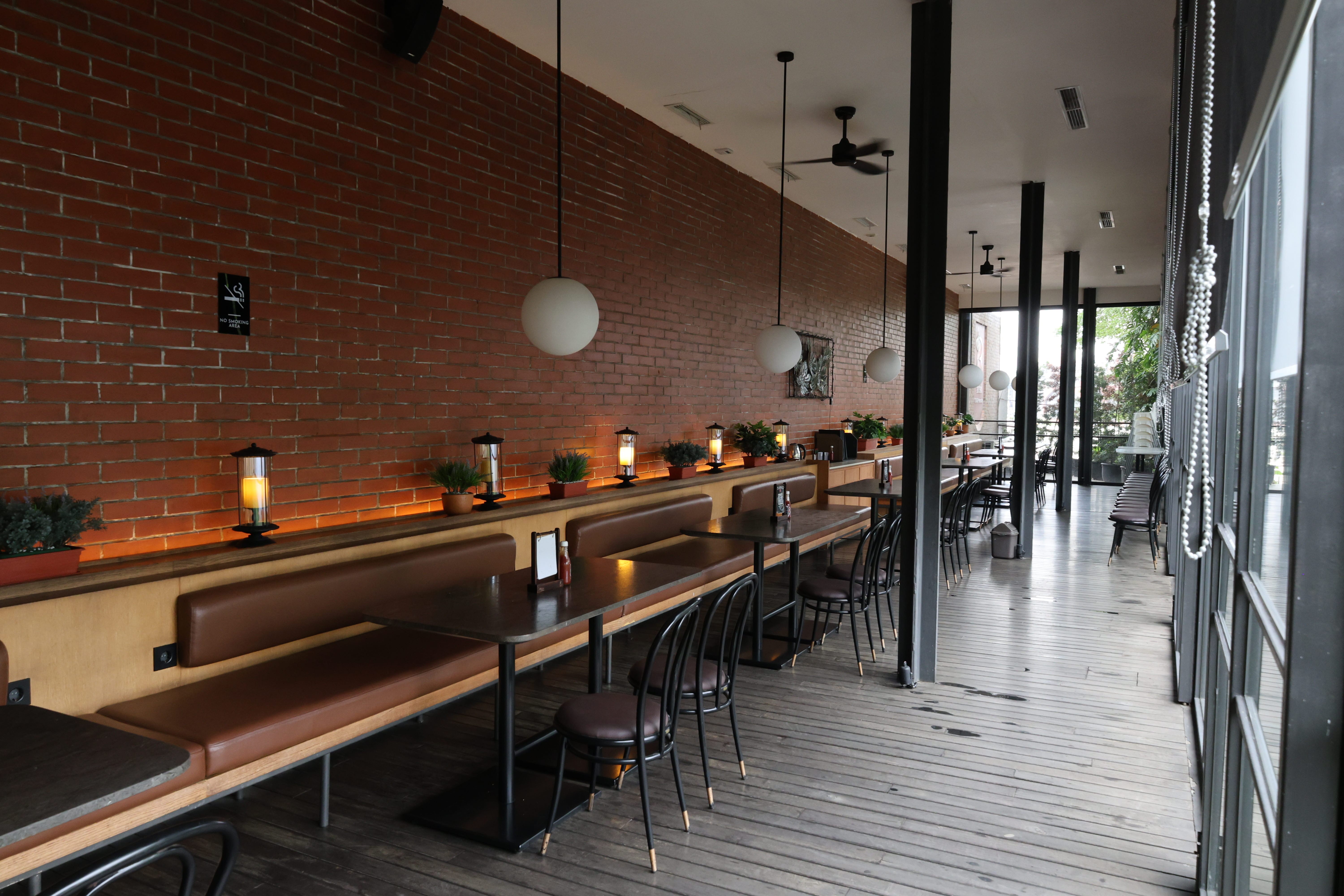 Outdoor terrace at BSteak with hardwood decking floor, solid wood bench seating, and wood wall panels by Reywood